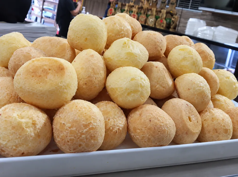 Bandeja cheia de pão de queijo quentinho